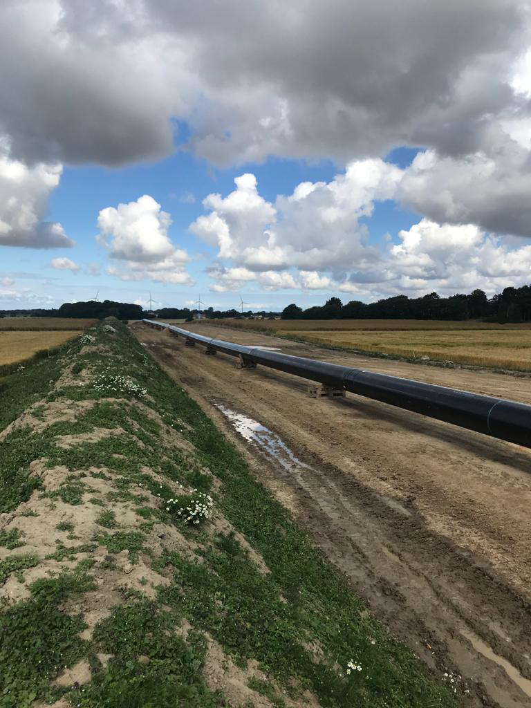 Baltic pipe line above ground with windmills in the background